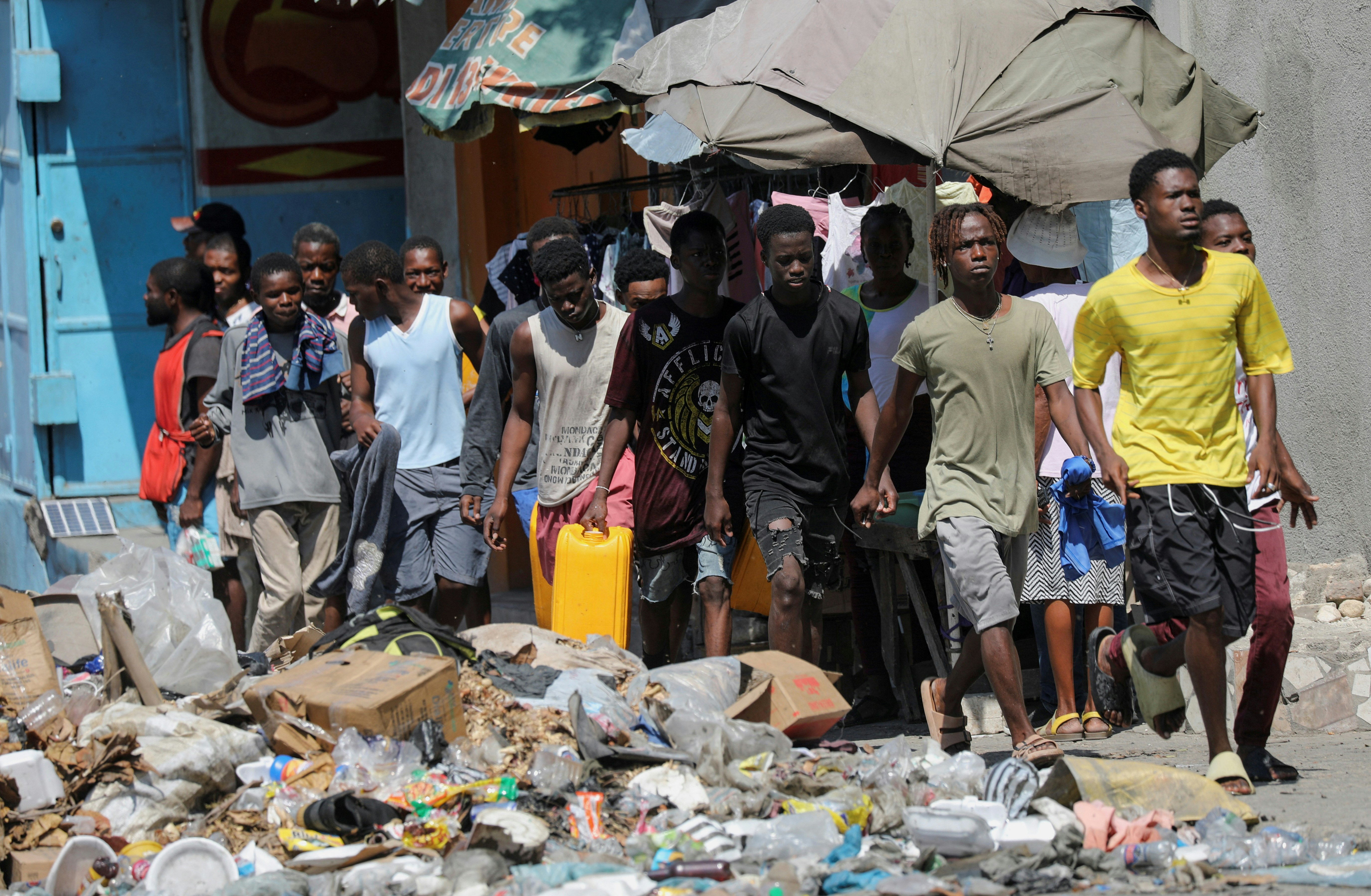 Des Haïtiens allant collecter de l'eau après l'annonce du départ d'Ariel Henry, le 12 mars 2024 à Port-au-Prince. Photo: Ralph Tedy Erol / Reuters