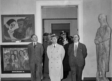 Goebbles visitant l'exposition "L'art dégénéré" en 1937. À gauche, deux œuvres d'Emil Nolde, et à droite une sculpture de Gerhard Marcks.